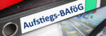 Büroordner mit der Aufschrift Aufstiegs- BAföG auf Euro-Scheinen liegend.