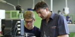 Feinwerkmechaniker Azubi und Meister in der Werkstatt.